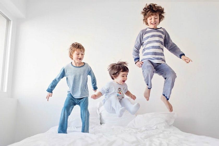 Children jumping wildly on the bed before sleep
